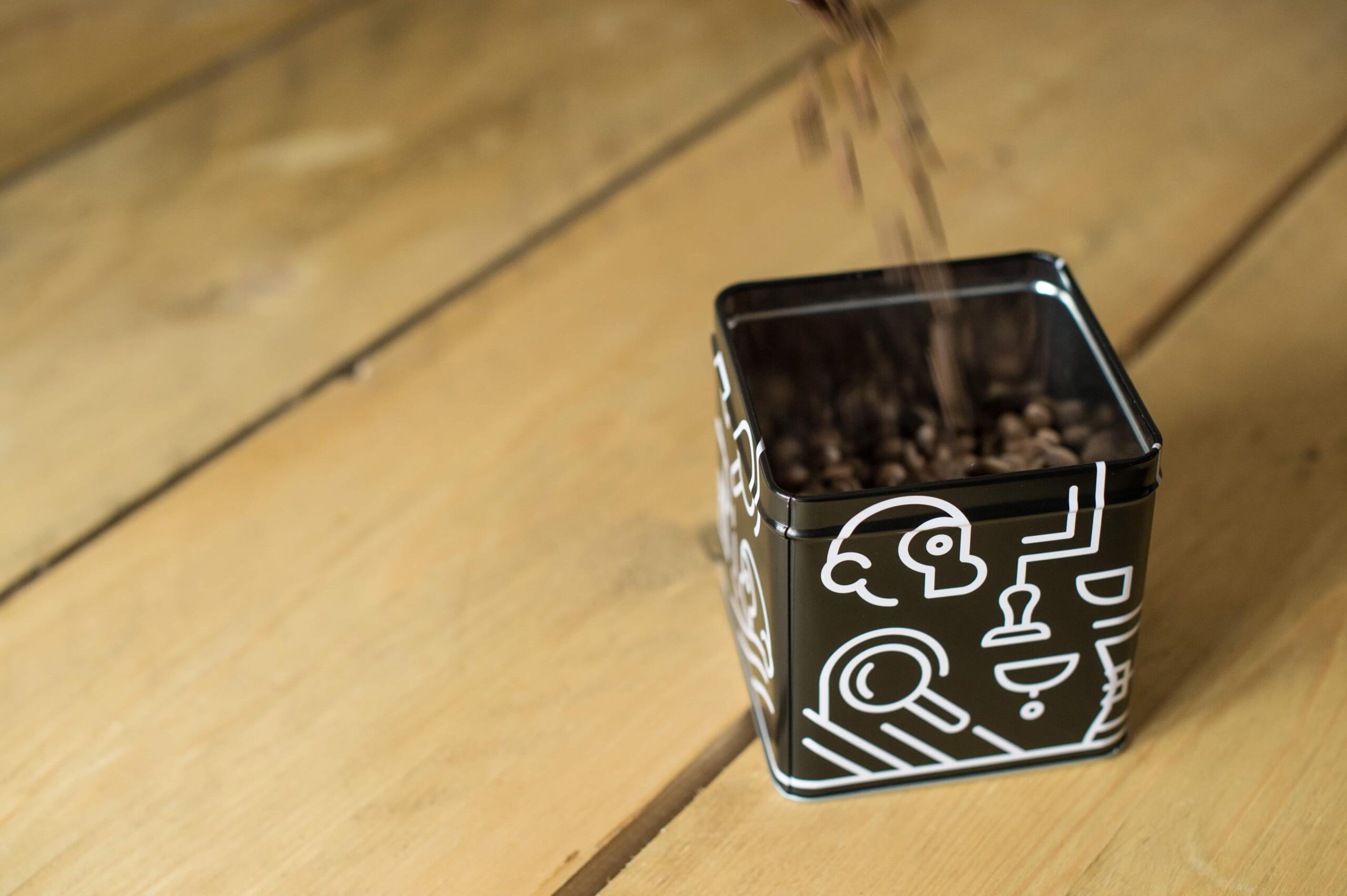 coffee beans being poured into a tin