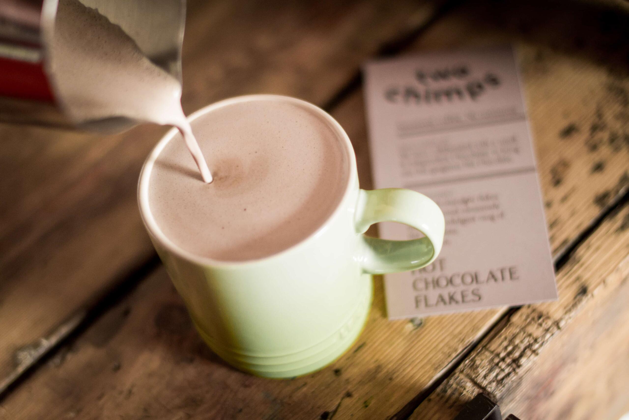 pouring hot chocolate into a green mug