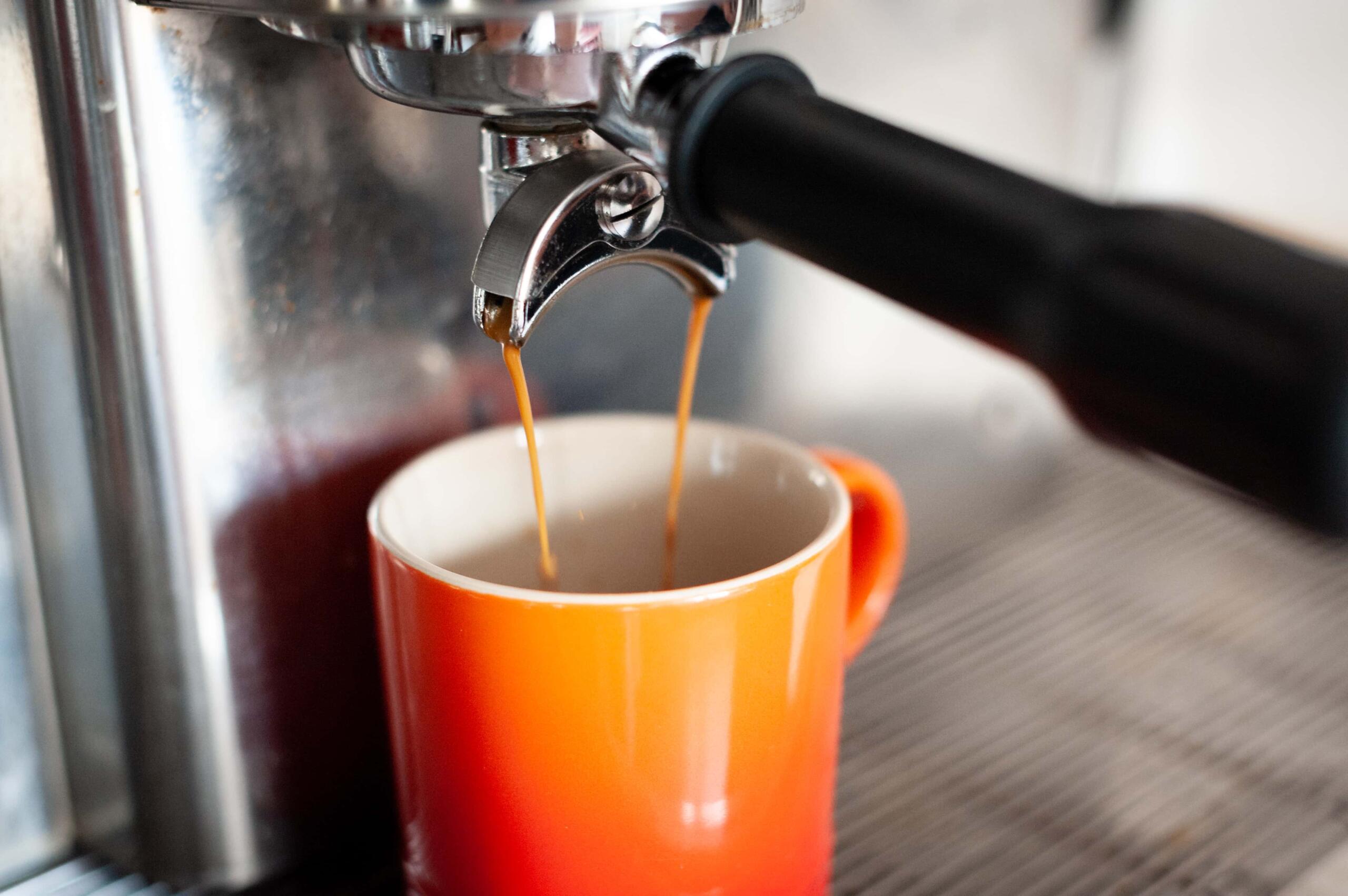 a shot of espresso pouring into a mug