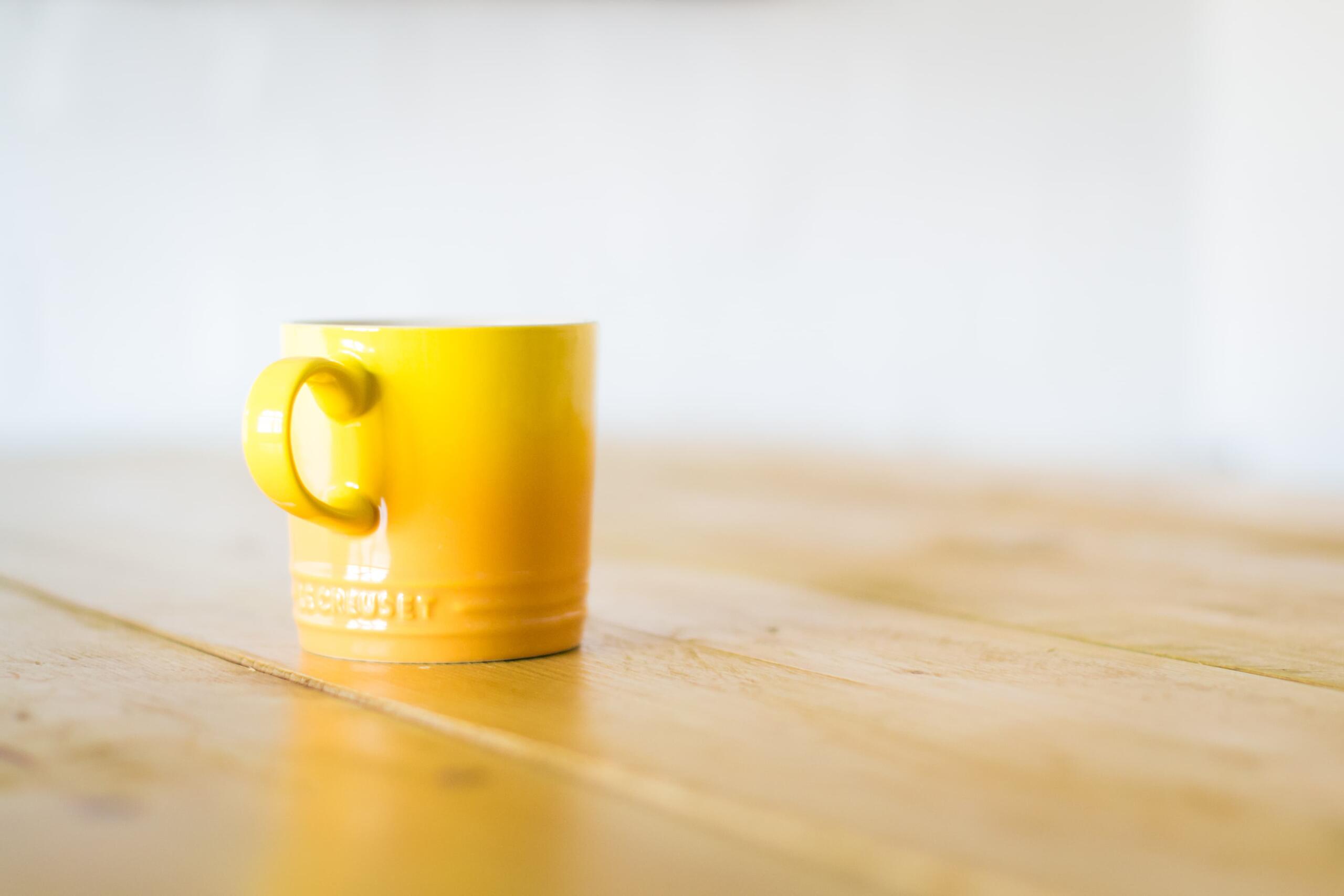 a yellow mug on a coffee table