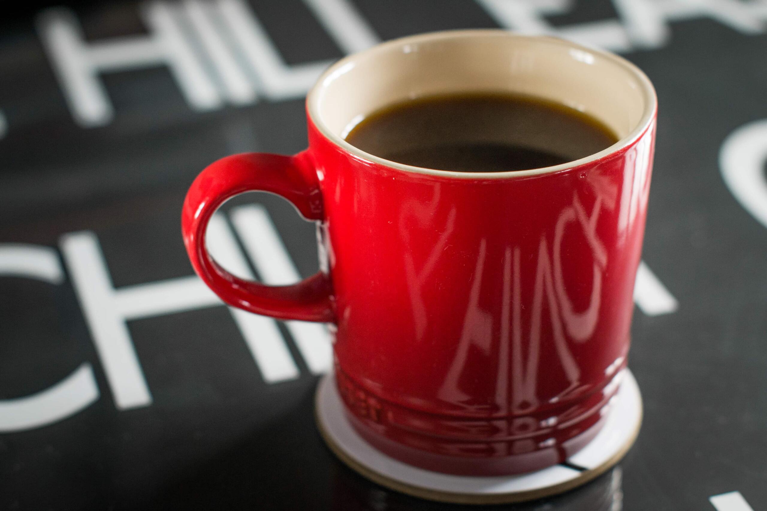 Red mug of coffee on black table