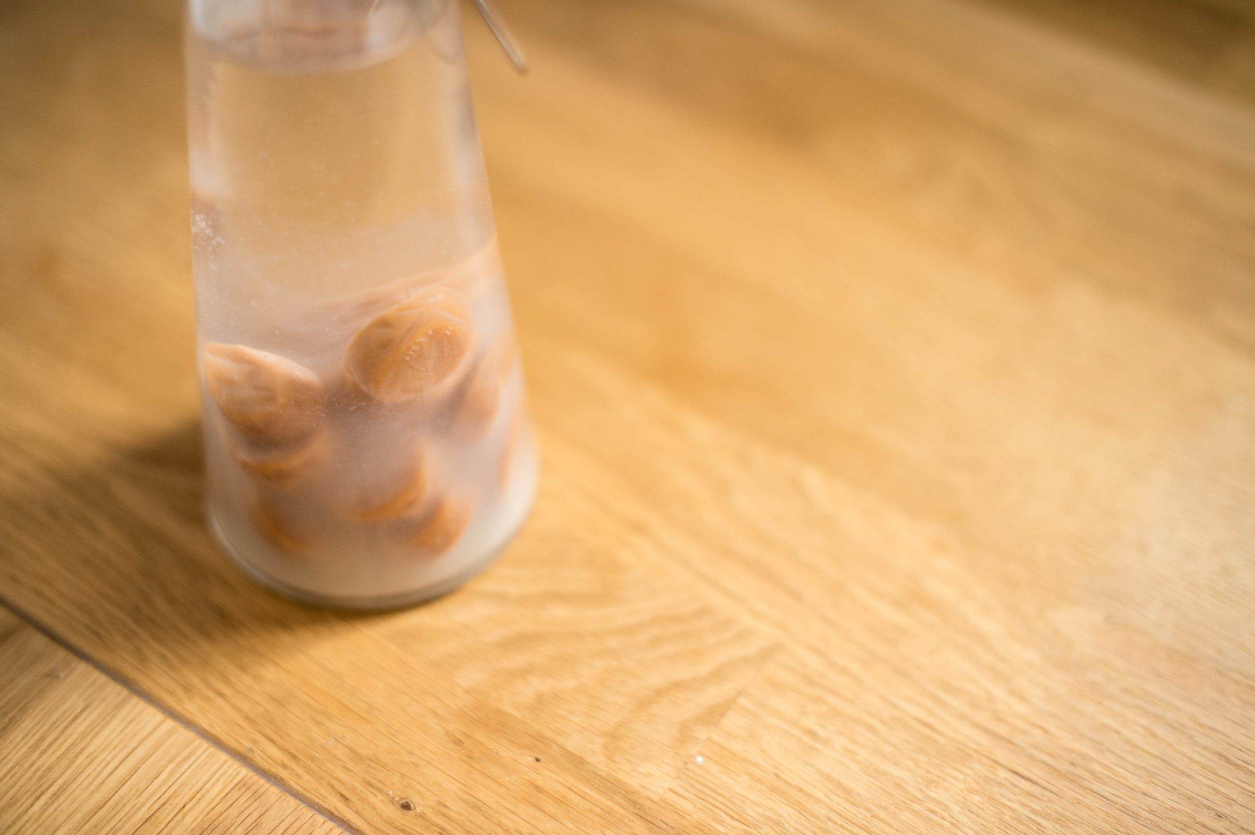 A close up of chewy caramel sweets in a bottle of vodka