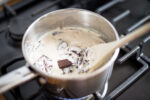 melting chocolate into a saucepan of cream