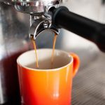 a shot of espresso pouring into a mug