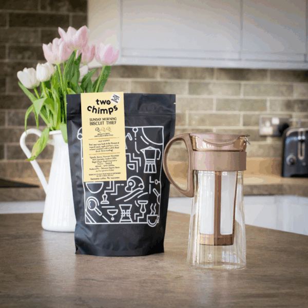 Cold brew gift set with a bag of coffee and vase of tulips