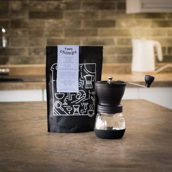 unboxed hario skerton coffee grinder with a bag of two chimps coffee on a kitchen worktop