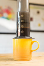 Areopress on top of yellow mug