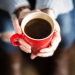 holding a red coffee mug