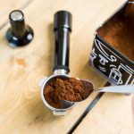 Adding ground coffee to a portafilter