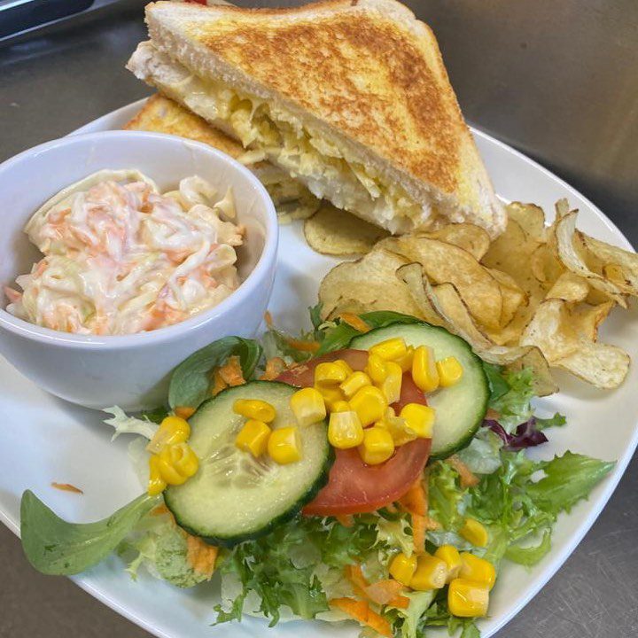Cheese sandwich with crisps, salad and coleslaw