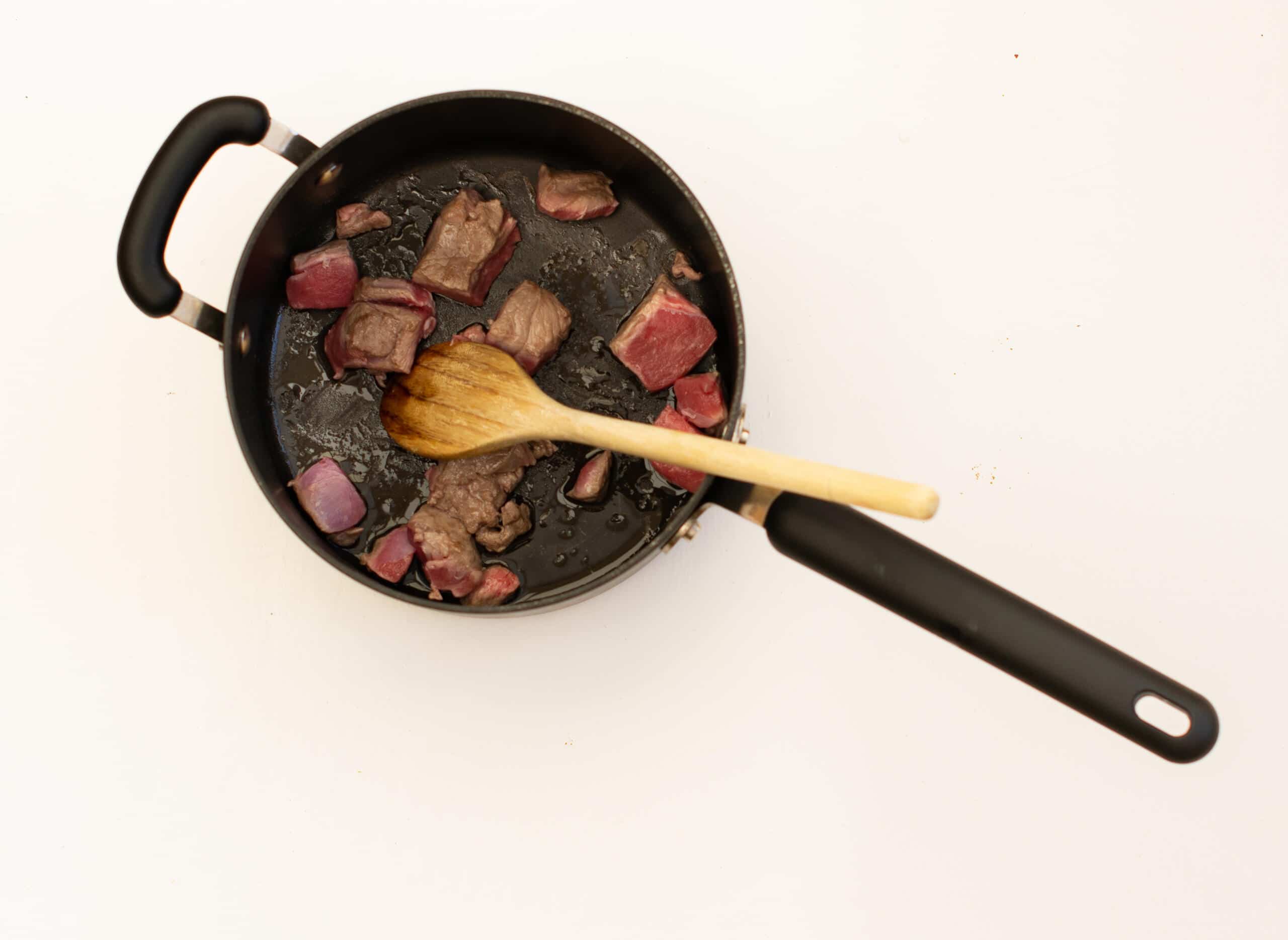 Overhead shot of lamb browning in saucepan