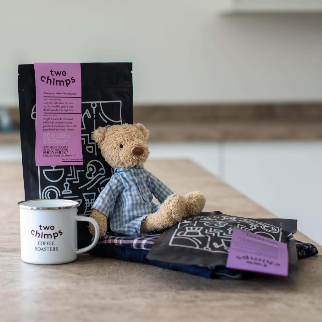 Bags of decaf coffee with teddy bear and Two Chimps mug
