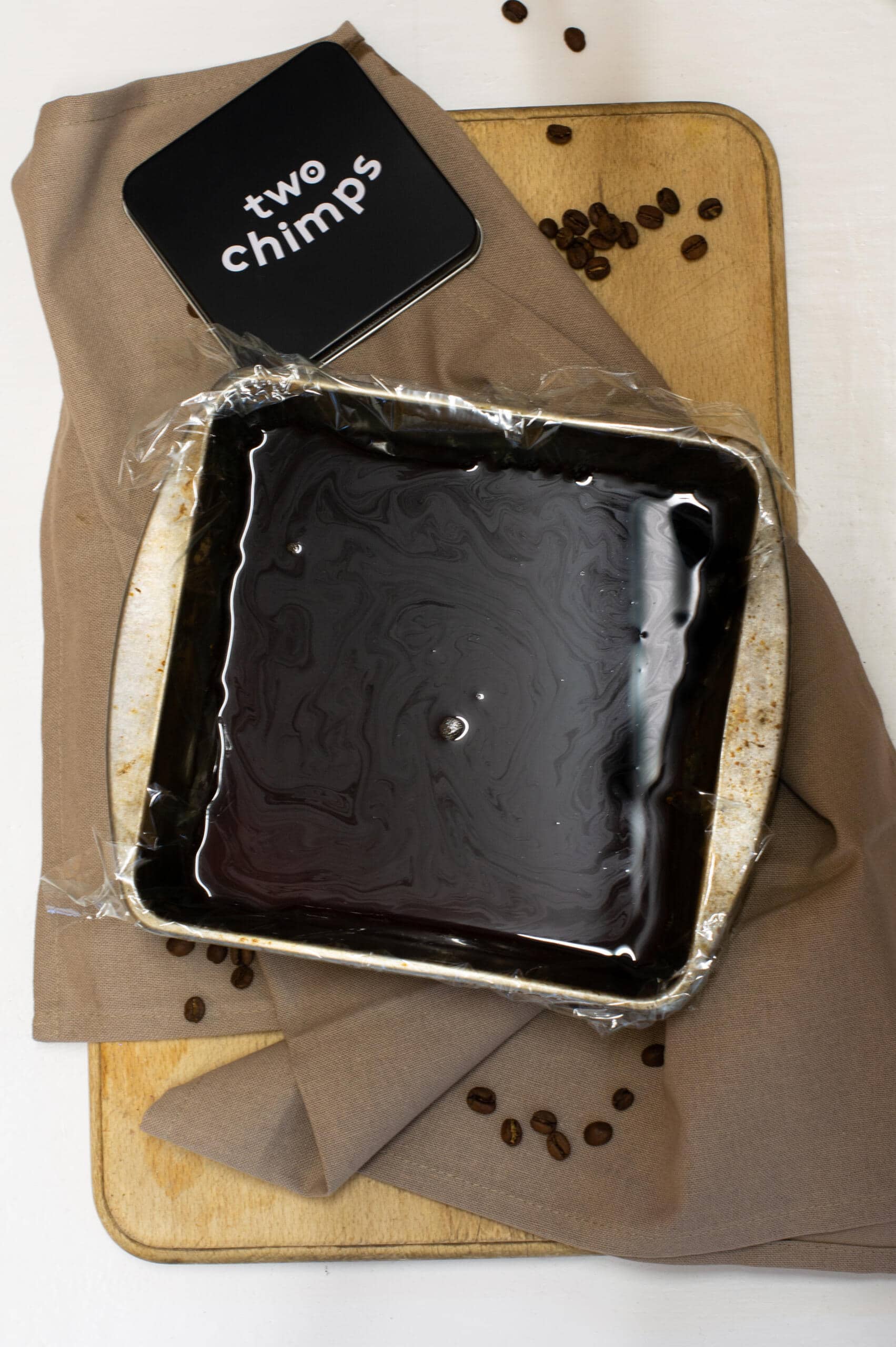 Coffee jelly mixture in a tin on tea towel