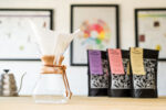 Chemex coffee maker beside three bags of Two Chimp coffee