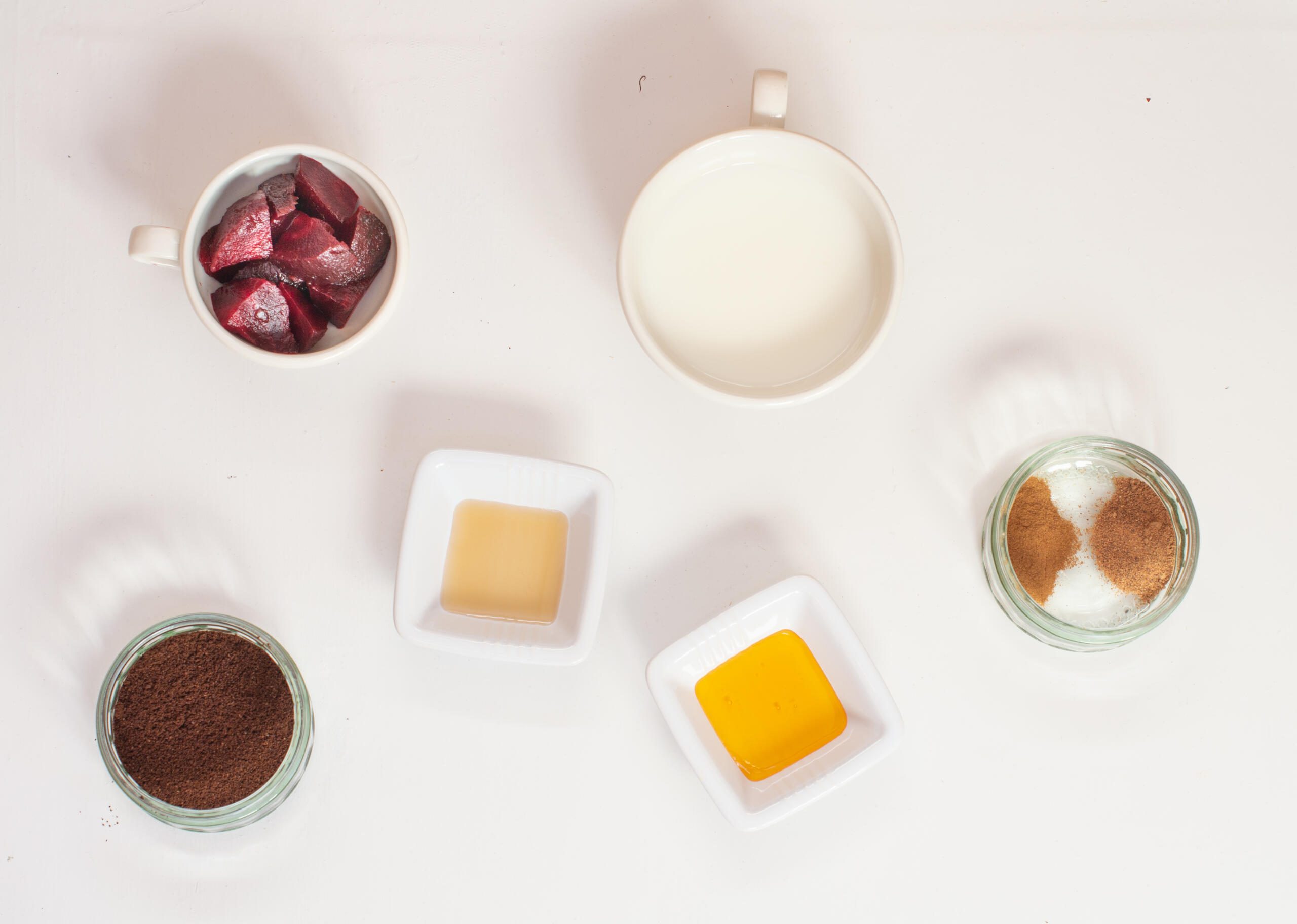 Ingredients for beetroot latte laid out on a white board
