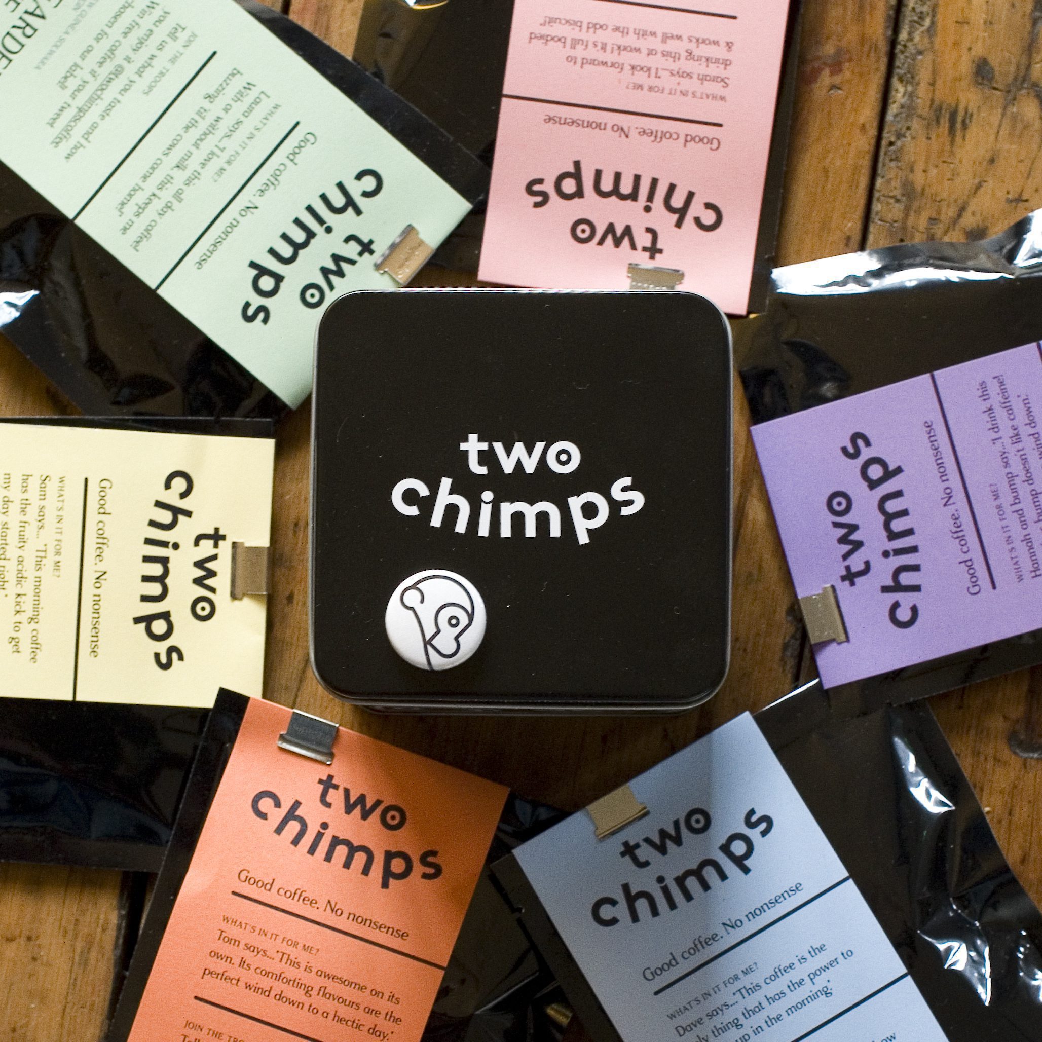 Two Chimps coffee samples surrounding branded black coffee tin