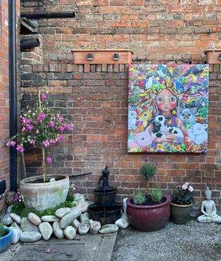 Modern art print on brick wall with plants and stones 
