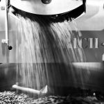 black and white image of coffee beans pouring out from the diedrick coffee machine