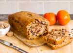 Earl Grey Tea loaf on chopping board besides oranges and brown sugar cubes 