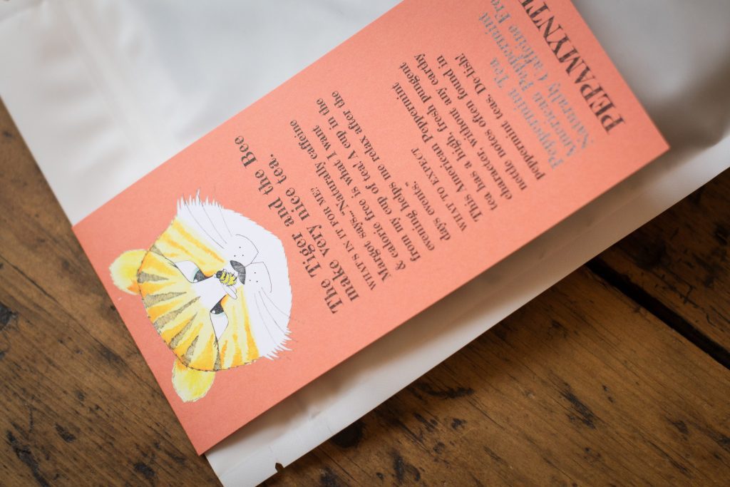 Bag of loose peppermint tea resting on a wooden table at an angle