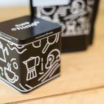 Two Chimps metal coffee tin and coffee pouch on a wooden table