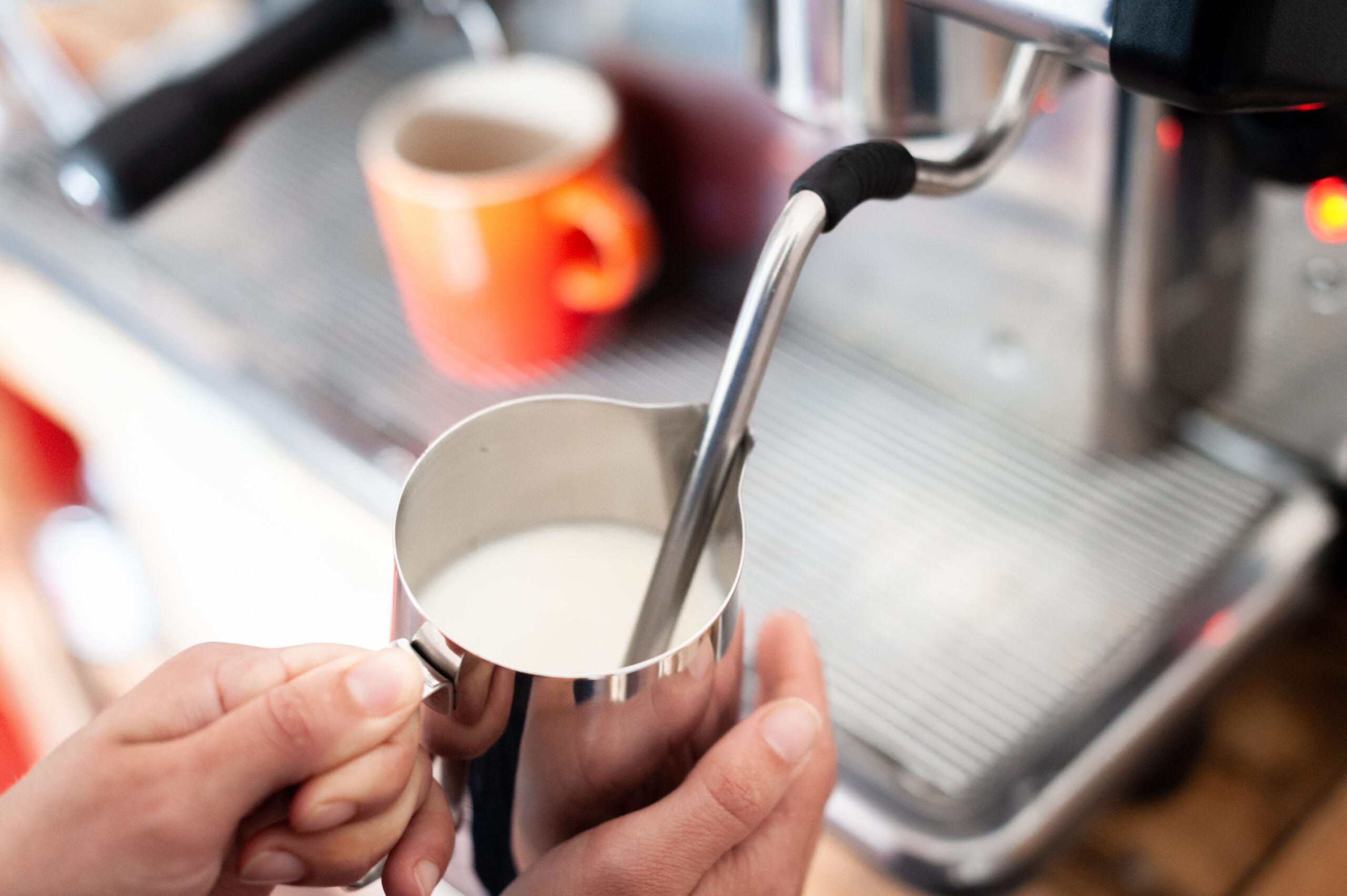 Steaming milk in a metal jug using a steam wand