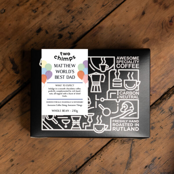 A personalised coffee box on a wooden table, featuring World's Best Dad messaging for Father's Day