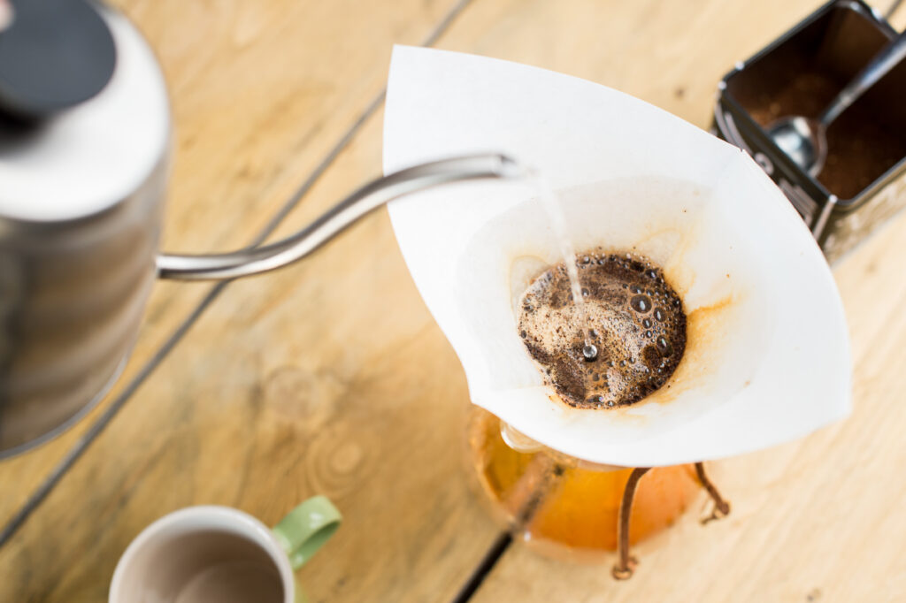 Pouring water over coffee ground in chemex